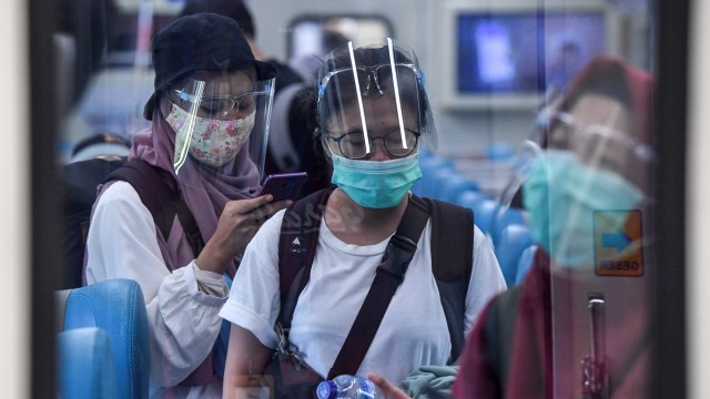 Penumpang menggunakan faceshield dan masker saat menaiki Kereta Api Turangga tujuan Surabaya Gubeng di Stasiun Gambir, Jakarta, Kamis (20/8). Foto: Hafidz Mubarak A/ANTARA FOTO