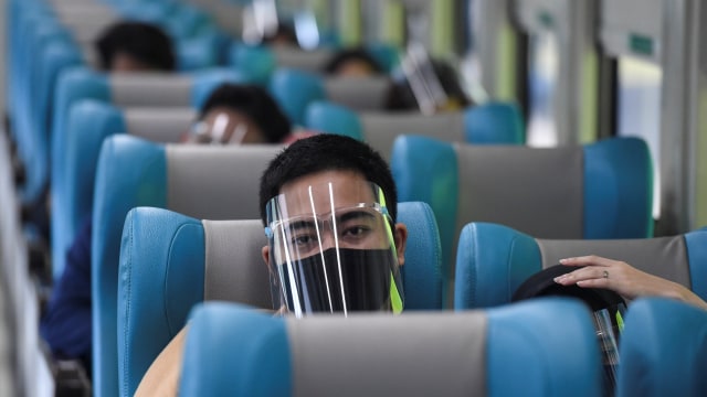 Penumpang menggunakan face shield dan masker saat menaiki Kereta Api Turangga tujuan Surabaya Gubeng di Stasiun Gambir, Jakarta, Kamis (20/8/2020). Foto: Hafidz Mubarak A/ANTARA FOTO
