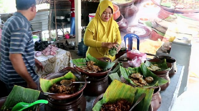 Pemilik Warung Sincin, Puspita Sari, saat melayani para pembeli Sego Buwuhan di warungnya, di Jalan MH Thamrin Gang Mawar, Kauman, Bojonegoro. Kamis (20/08/2020)