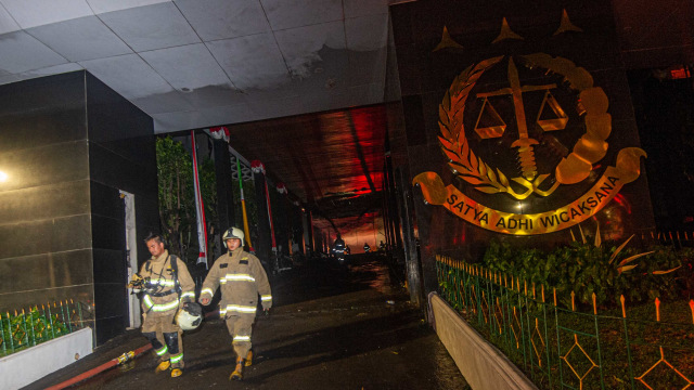 Dua petugas pemadam kebakaran keluar gedung utama Kejaksaan Agung yang terbakar untuk bergantian bertugas di Jakarta, Minggu (23/8/2020). Foto: ADITYA PRADANA PUTRA/ANTARA FOTO