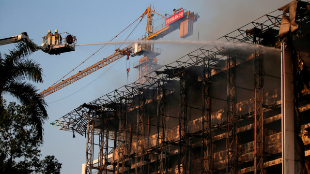 Petugas pemadam kebakaran berusaha mendinginkan kebakaran di kantor Kejaksaan Agung, Jakarta. Foto: Willy Kurniawan/REUTERS