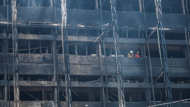 Petugas Pemadam Kebakaran melakukan proses pendinginan di gedung utama Kejaksaan Agung yang terbakar di Jakarta, Minggu (23/8). Foto: Galih Pradipta/ANTARA FOTO
