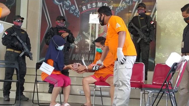 Tersangka NL (otak pembunuhan) memberikan uang ke pembunuh bayar dalam rekonstruksi di Polda Metro Jaya. Foto: Dok. Istimewa