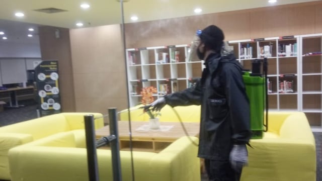 Petugas menyemprotkan cairan disinfektan di Gedung KPK, Jakarta. Foto: Humas KPK