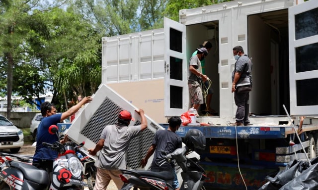 Pekerja menyiapkan laboratorium uji swab yang baru tiba. Foto: Suparta/acehkini