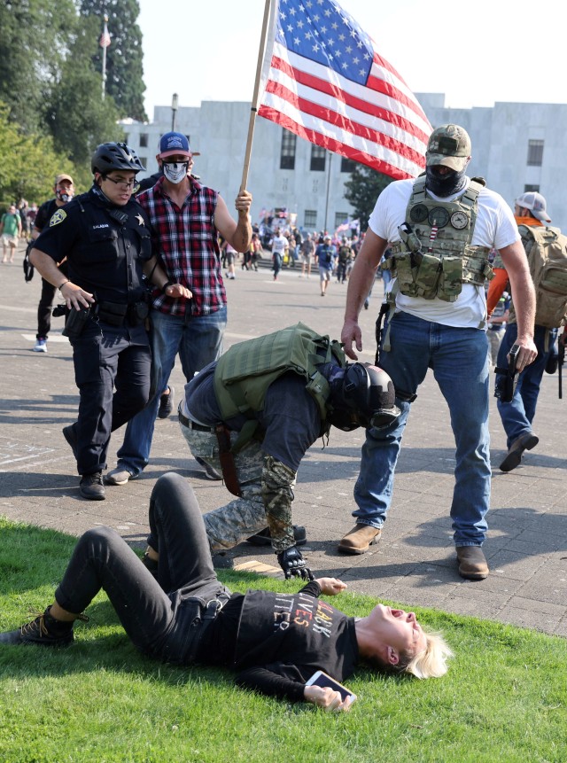 Petugas polisi membubarkan perkelahian antara pendukung Presiden AS Donald Trump dan pengunjuk rasa Black Lives Matter di luar gedung Oregon State Capitol di Salem, Oregon, Portland, Amerika Serikat. Foto: Carlos Barria/Reuters