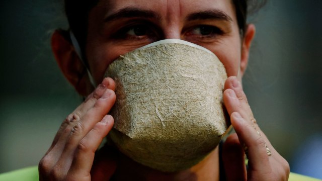 Sandrine Boudier, petugas pemasaran perusahaan Prancis Geochanvre, berpose dengan masker serta ganja di di Lezinnes, Prancis. Foto: CHARLES PLATIAU/REUTERS