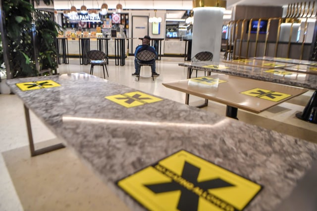 Seorang calon pembeli menunggu makanan pesanannya di mall Senayan City, Jakarta, Senin (14/9). Foto: Muhammad Adimaja/Antara Foto