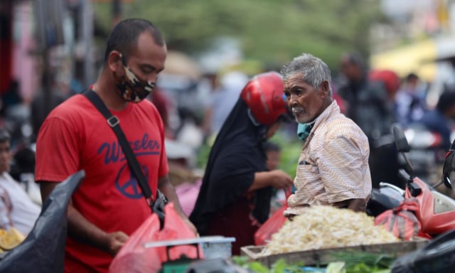 Pedagang dengan masker di pasar Peunayong, Banda Aceh. Foto: Suparta/acehkini
