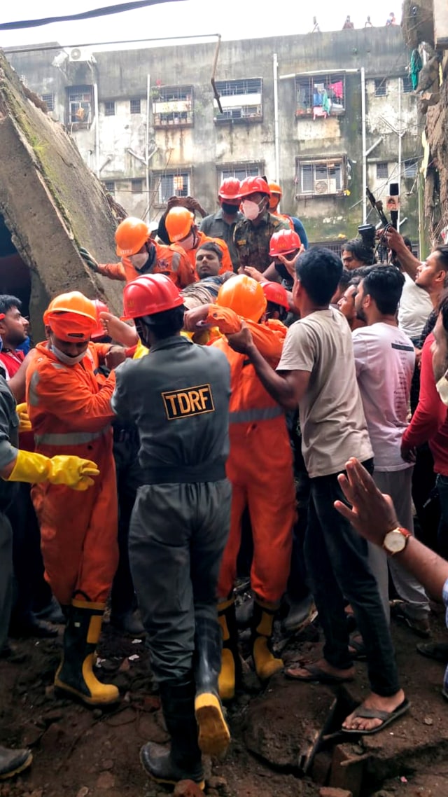 Pasukan Tanggap Bencana Nasional (NDRF) saat mengevakuasi korban selamat setelah bangunan tempat tinggal runtuh di Bhiwandi di pinggiran Mumbai, India, (21/9). Foto: Praful Gangurde/AP Photo