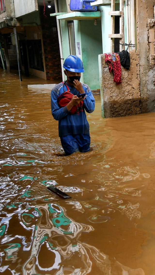 Warga berjalan melintasi banjir di Kebon Pala, Jatinegara, Jakarta Timur, Selasa (22/9/2020). Foto: Galih Pradipta/ANTARA FOTO