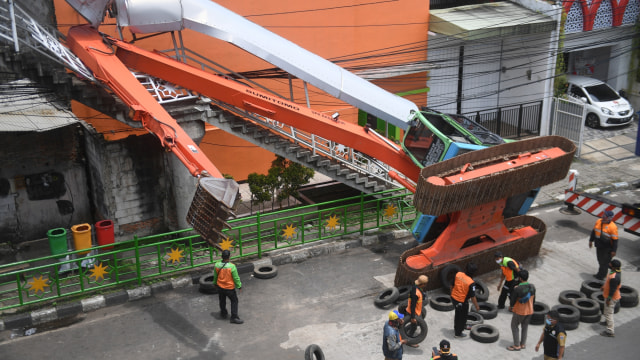 Petugas mengevakuasi ekskavator yang terguling menimpa tangga jembatan penyeberangan orang (JPO) di Jalan Abdullah Syafei, Kampung Melayu, Tebet, Jakarta, Selasa (22/9). Foto: Akbar Nugroho Gumay/ANTARA FOTO