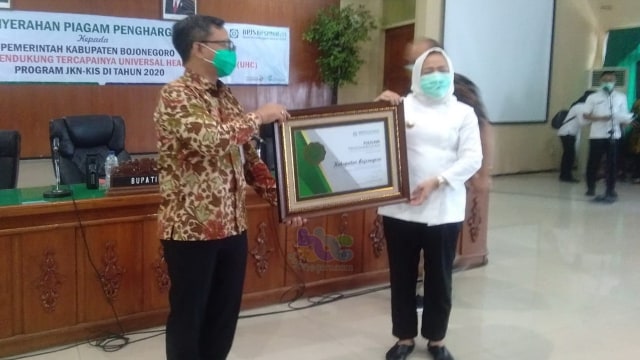 Bupati Bojonegoro, Dr Hj Anna Muawanah, saat terima Piagam penghargaan UHC, dari Kepala Divisi Regional (Divre) BPJS Jawa Timur.