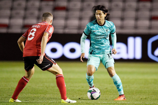 Pemain Liverpool Takumi Minamino berusaha melewati pemain Lincoln City pada pertandingan Piala Carabao di Sincil Bank, Lincoln, Inggris. Foto: Peter Powell/REUTERS