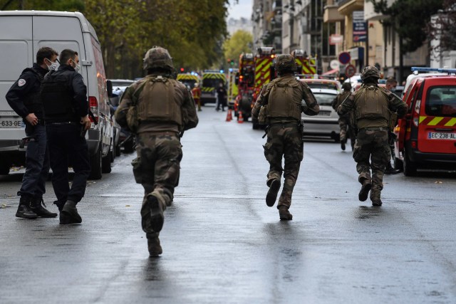 Petugas polisi Prancis bergegas ke tempat kejadian penyerangan di dekat bekas kantor majalah satir Prancis Charlie Hebdo di Paris, Prancis. Foto: Alain Jocard/AFP