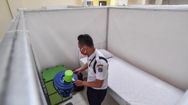 Petugas merapikan ruang isolasi mandiri pasien COVID-19 di Gelanggang Remaja Kecamatan Pademangan, Jakarta, Minggu (27/9). Foto: Muhammad Adimaja/ANTARA FOTO
