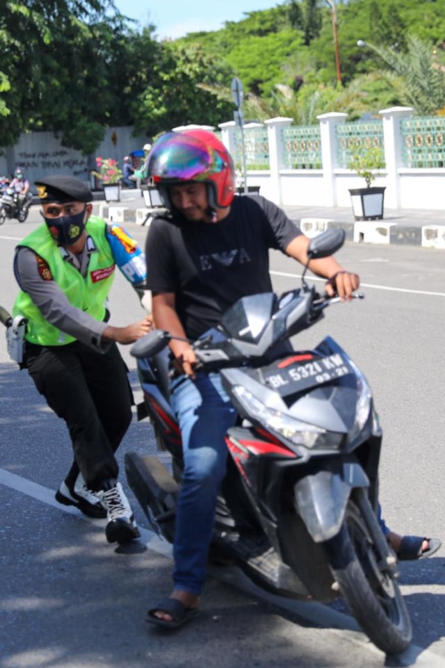 Petugas tim Peucrok menghentikan warga yang tidak menggunakan masker, Senin (28/9). Foto: Suparta/acehkini