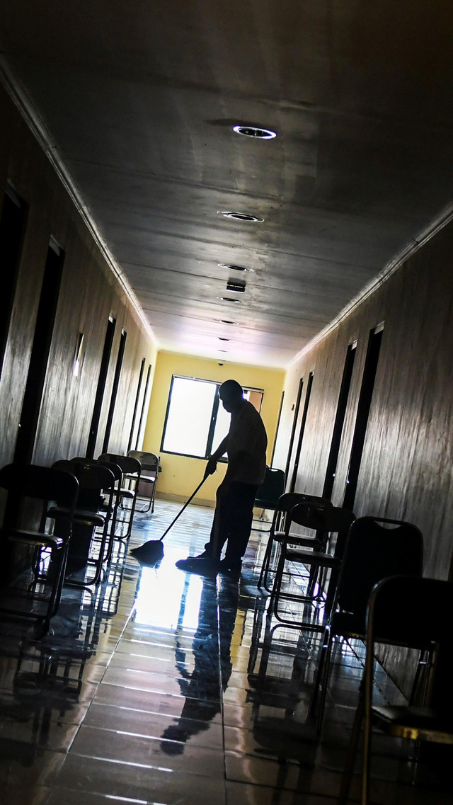 Petugas membersihkan lantai di ruang isolasi mandiri pasien COVID-19 di Graha Wisata Ragunan, Jakarta, Rabu (30/9). Foto: Galih Pradipta/ANTARA FOTO