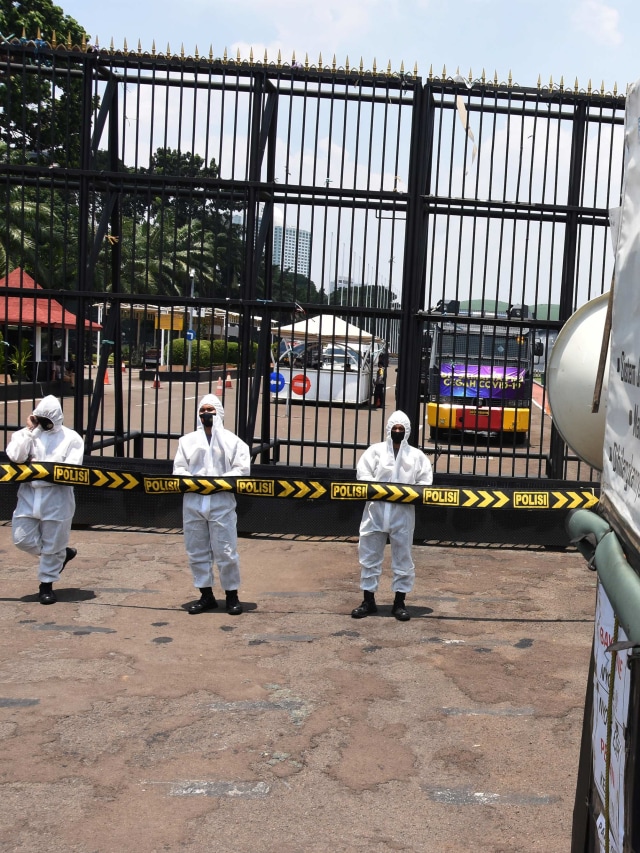 Polisi yang mengenakan pakaian APD berjaga saat aksi unjuk rasa buruh menolak pengesahan RUU Omnibus Law Cipta Lapangan Kerja di depan gedung DPR, Jakarta, Rabu (30/9). Foto: Indrianto Eko Suwarso/Antara Foto