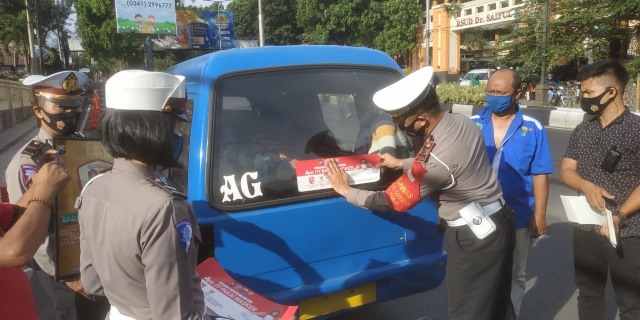 Kasatlantas Polresta Malang Kota, AKP Ramadhan Nasution, memimpin langsung operasi pemasangan stiker imbauan protokol kesehatan. Foto: Ulul Azmy