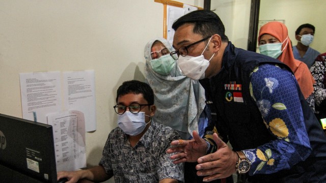 Gubernur Jawa Barat Ridwan Kamil (kanan) berbincang dengan petugas saat meninjau Fasilitas Labkesda Kota Depok di Cimanggis, Depok, Jawa Barat, Jumat (2/10). Foto: Asprilla Dwi Adha/ANTARA FOTO