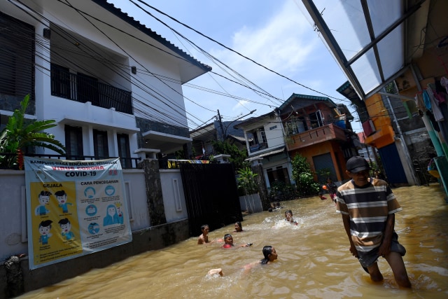 Sejumlah anak bermain air saat banjir melanda kawasan permukiman di Petogogan, Kebayoran Baru, Jakarta Selatan, Senin (5/10).  Foto: Sigid Kurniawan/ANTARA FOTO