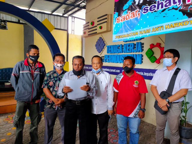 Perwakilan serikat buruh di Kota Tegal membacakan pernyataan sikap untuk tidak ikut aksi mogok nasional di Halaman Disnakerin Kota Tegal, Senin (5/10/2020). (Foto: Setyadi)