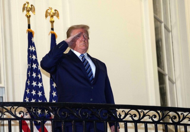 Presiden AS Donald Trump melihat keluar dari Truman Balcony saat tiba di Gedung Putih sekembalinya dari Walter Reed Medical Center, tempat dia menjalani perawatan untuk Covid-19. Foto: Nicholas Kamm/ AFP