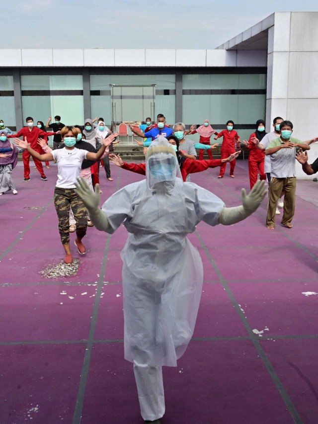 Seorang instruktur senam yang mengenakan APD memimpin senam pagi untuk pasien virus corona COVID-19 di sebuah hotel di Karawaci,  Banten, Indonesia, Senin (5/10). Foto: Adek Berry/AFP