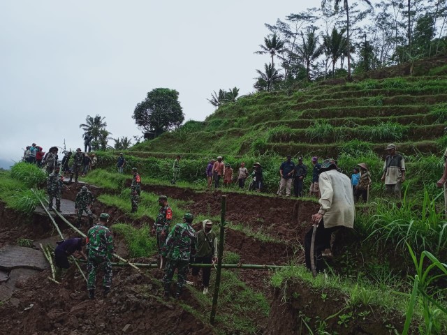 Jajaran TNI dari Kodim 0615/Kuningan turun ke lapangan untuk membantu warga memperbaiki akses jalan desa di Desa Jatisari Kecamatan Subang, Kabupaten Kuningan, Jawa Barat. (Andri)