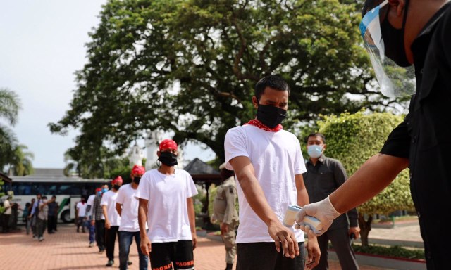 Nelayan yang dipulangkan dari Thailand dicek suhu tubuh saat disambut Wakil Ketua Satgas COVID-19 Aceh di Pendopo Gubernur Aceh, Selasa (6/10). Foto: Suparta/acehkini 