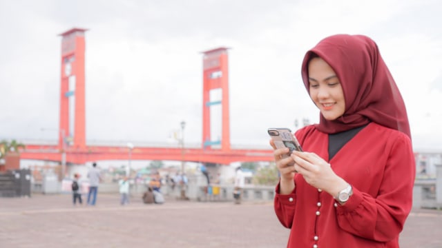 Ilustrasi memegang smartphone. Foto: Telkomsel