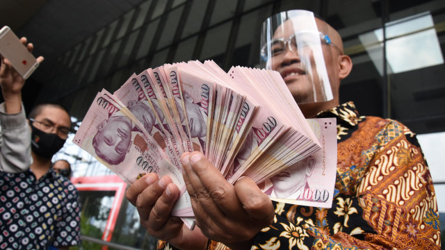 Koordinator Masyarakat Anti Korupsi Indonesia (MAKI) Boyamin Saiman menunjukkan uang diduga suap yang diterimanya, sebelum diserahkan ke KPK, Jakarta, Rabu (7/10).  Foto: Indrianto Eko Suwarso/ANTARA FOTO