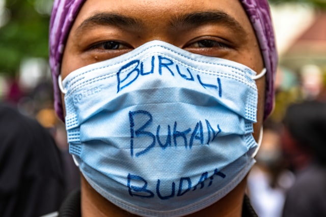 Pengunjuk rasa mengenakan masker dengan tulisan Buruh Bukan Budak saat mengikuti unjuk rasa menolak RUU Cipta Kerja Omnibus Law yang telah disahkan oleh DPR RI di depan gedung DPRD Jateng, Kota Semarang, Jawa Tengah, Rabu (7/10).  Foto: Aji Styawan/ANTARA FOTO