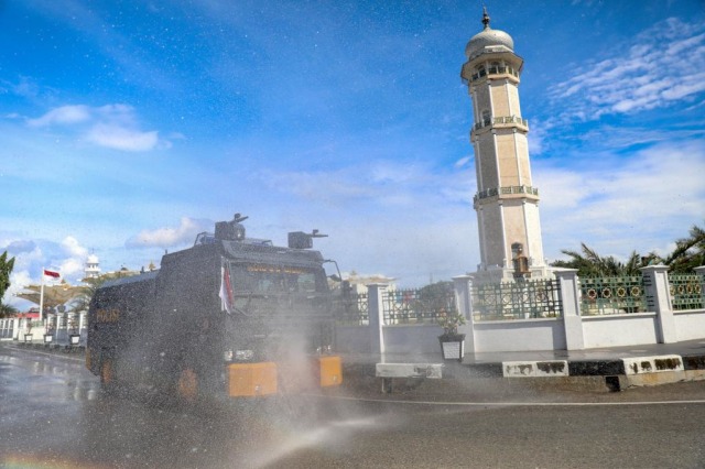 Jalan di depan Masjid Raya Baiturrahaman, Banda Aceh, disemprot disinfektan guna menekan penularan COVID-19, Jumat (25/9). Foto: Suparta/acehkini