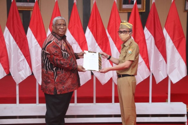 Gubernur Sultra, Ali Mazi (batik) menyerahkan SK kepada Pjs. Bupati Buton Utara, Hery Alamsyah. Foto: Diskominfo Sultra.