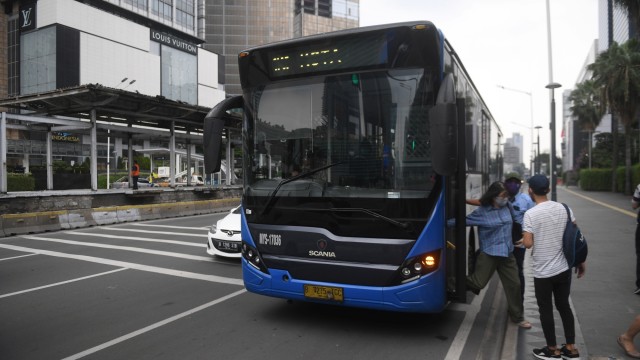 Penumpang turun dari bus Transjakarta di samping halte Bundaran HI yang hangus terbakar, di Jakarta, Sabtu (10/10). Foto: Akbar Nugroho Gumay/ANTARA FOTO