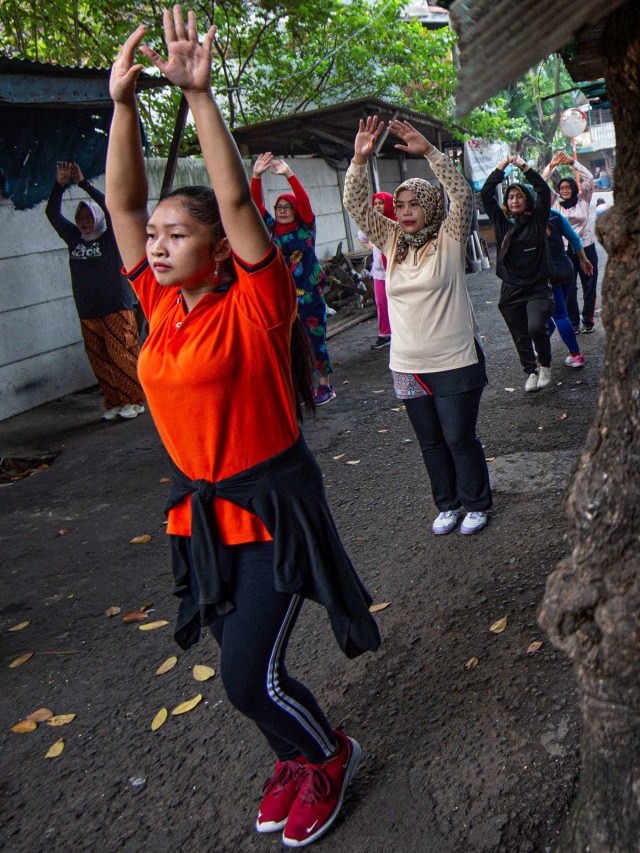 Warga di jalan perkampungan di Duri Pulo, Jakarta melakukan senam aerobik. Foto: Aditya Pradana Putra/Antara Foto