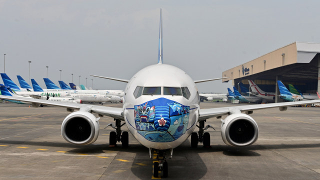Pesawat Garuda Indonesia Boeing 373-800 NG dengan desain masker baru sebagai bagian dari kampanye penggunaan masker di tengah pandemi COVID-19. Foto: ADEK BERRY/AFP