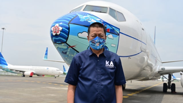 Direktur Utama Garuda Indonesia Irfan Setiaputra bediri di depan Pesawat Garuda Indonesia Boeing 373-800 NG dengan desain masker baru sebagai bagian dari kampanye penggunaan masker di tengah pandemi COVID-19. Foto: ADEK BERRY/AFP