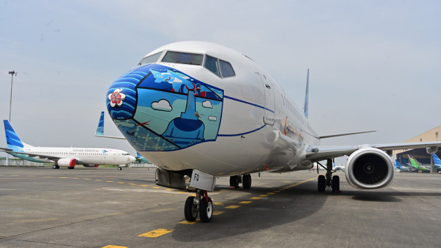 Pesawat Garuda Indonesia Boeing 373-800 NG dengan desain masker baru sebagai bagian dari kampanye penggunaan masker di tengah pandemi COVID-19. Foto: ADEK BERRY/AFP