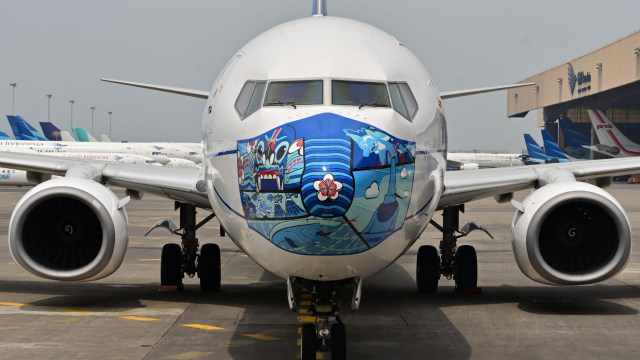 Pesawat Garuda Indonesia Boeing 373-800 NG dengan desain masker baru sebagai bagian dari kampanye penggunaan masker di tengah pandemi COVID-19. Foto: ADEK BERRY/AFP
