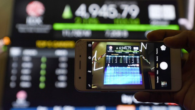Seorang pengunjung mengabadikan pergerakan Indeks Harga Saham Gabungan (IHSG) dengan gawainya di Bursa Efek Indonesia, Jakarta, Jumat (25/9). Foto: Puspa Perwitasari/ANTARA FOTO