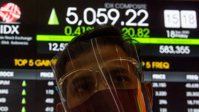 Petugas membelakangi layar informasi pergerakan harga saham pada layar elektronik di Bursa Efek Indonesia (BEI), Jakarta, Jumat (18/9). Foto: Aditya Pradana Putra/ANTARA FOTO