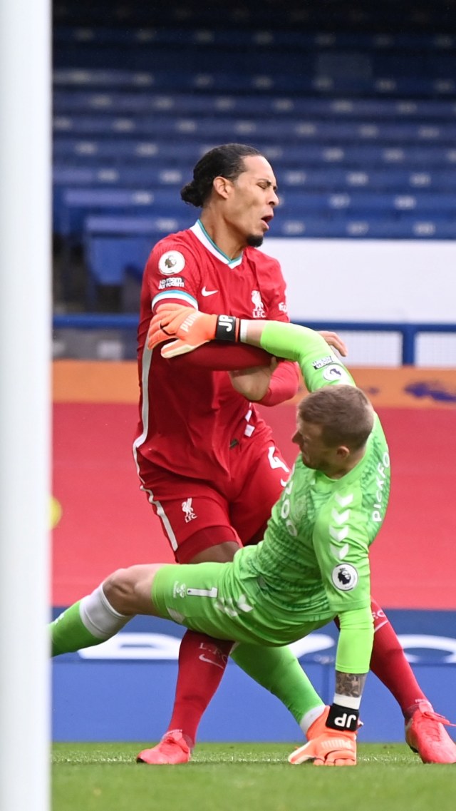 Pemain Liverpool Virgil van Dijk bertabrakan dengan Kiper Everton Jordan Pickford saat pertandingan Liga Premier Everton vs Liverpool di Stadion Goodison Park, Liverpool, Inggris, Sabtu (17/10). Foto: Laurence Griffiths/Pool via REUTERS