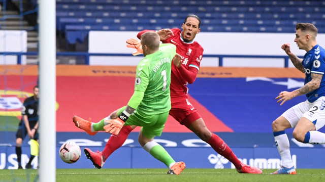 Pemain Liverpool Virgil van Dijk bertabrakan dengan Kiper Everton Jordan Pickford saat pertandingan Liga Premier Everton vs Liverpool di Stadion Goodison Park, Liverpool, Inggris, Sabtu (17/10). Foto: Laurence Griffiths/Pool via REUTERS