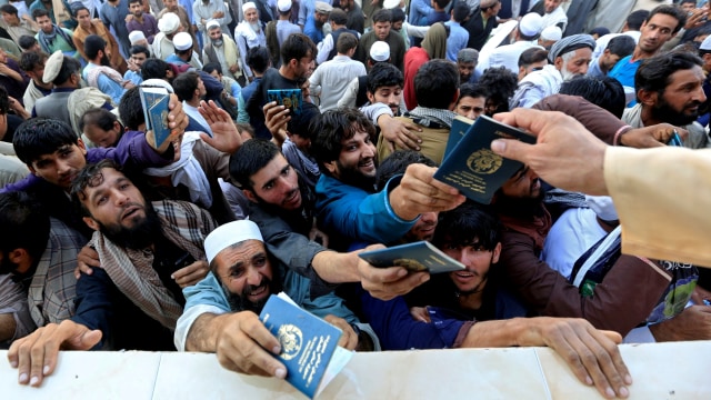 Sejumlah warga Afghanistan berebut untuk mendapatkan token yang dibutuhkan untuk mengajukan visa Pakistan, di Jalalabad, Afghanistan, Rabu (21/10). Foto: Parwiz/REUTERS