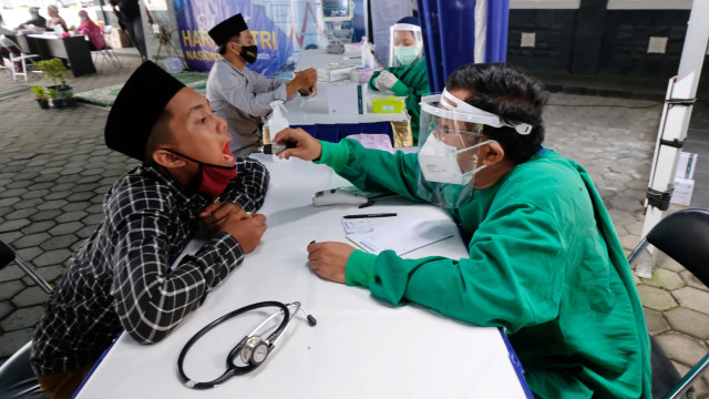 Petugas medis memeriksa kesehatan santri saat bakti sosial pengobatan gratis menyambut Hari Santri Nasional 2020 di kompleks RSU Syubbanul Wathon Tegalrejo, Magelang, Jawa Tengah, Kamis (22/10).  Foto: Anis Efizudin/ANTARA FOTO