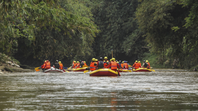Peserta mendayung perahu karet mengamati titik longsor di Ruas Sungai Ciliwung. Foto: ANTARA FOTO/Asprilla Dwi Adha