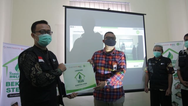 Iqbal Farizi, Kepala Perwakilan IZI Sumatera Utara (paling kiri) menerima giant-cheque dari Ersyad Hilmi, Business Manager BNI Syariah Kota Medan sebagai simbol atas diresmikannya Rumah Sehat Holistik di kota Medan. Dok IZI